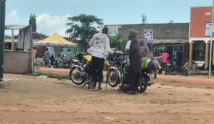 A member of the Mbororo and his wife taking a Boda Boda at Wudu town after buying goods from the market [photo by Denis Logonyi]